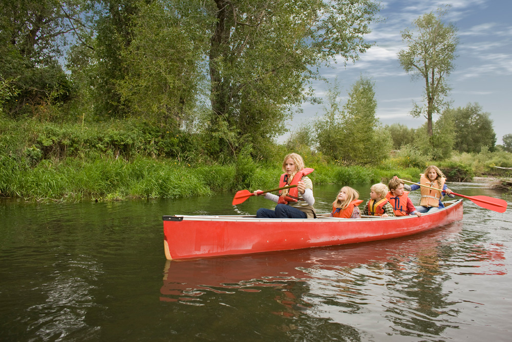 Familie beim Kanufahren auf dem Fluss